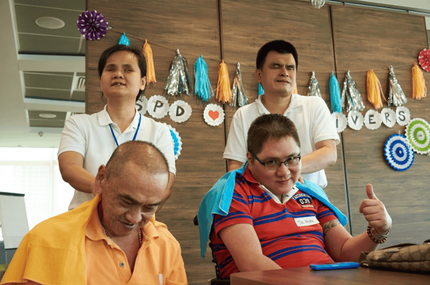 Mr Kua and Mr Lim enjoying a neck massage at a caregiver event organised by S P D