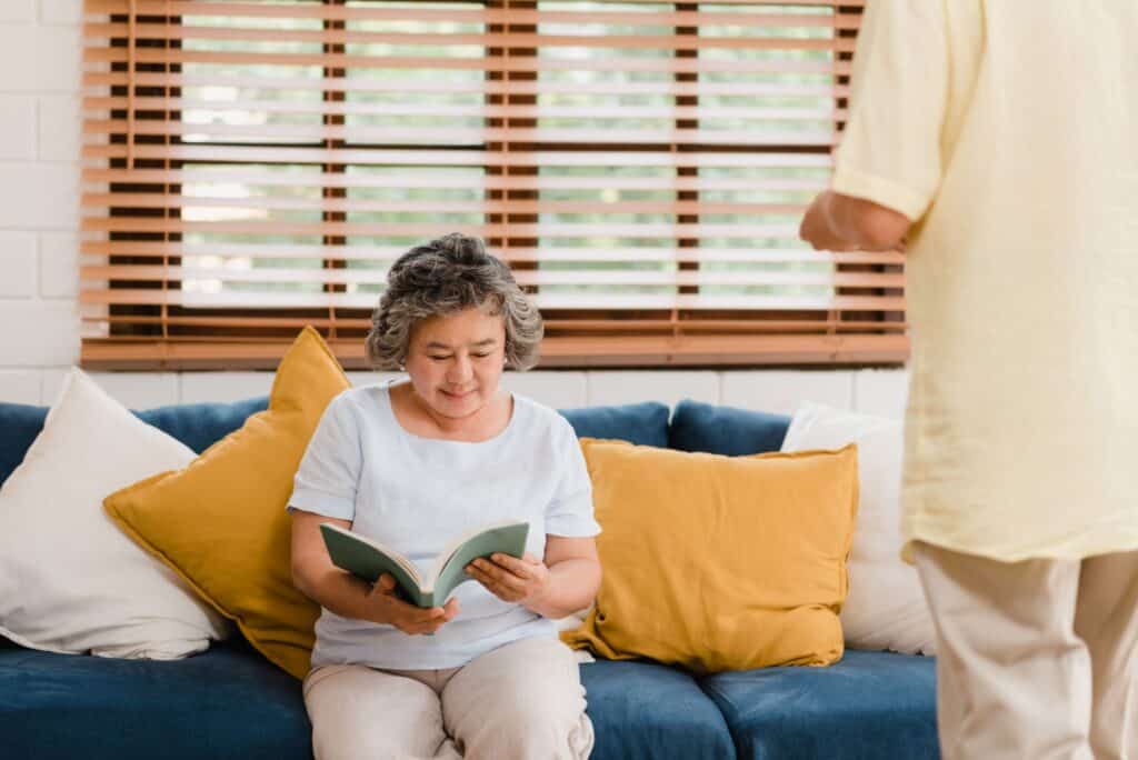 A woman reading a book in her living room