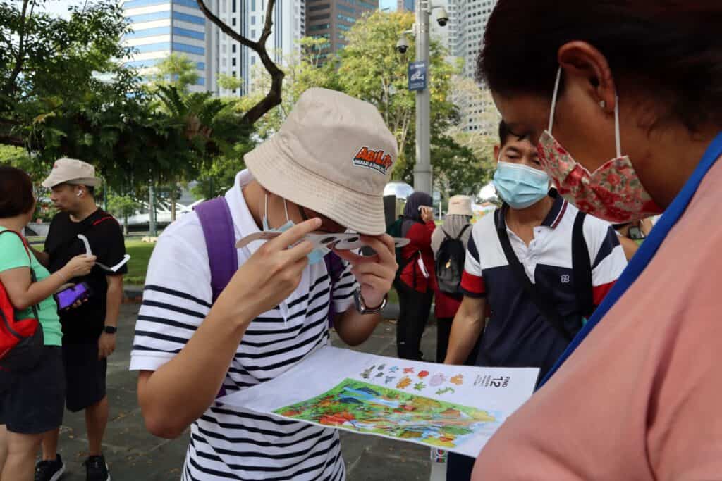 A man putting on an eyewear and looking at a piece of paper with pictures