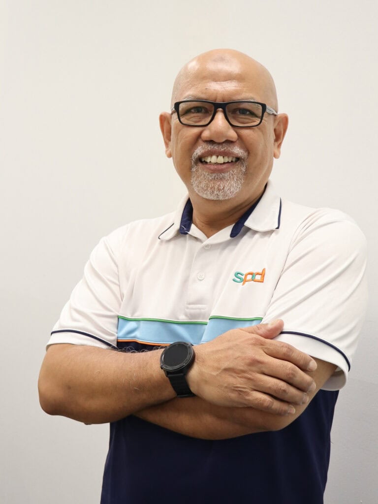 Employment and training executive  Abdul Rahim in blue and white S P D service tee, standing with arms crossed