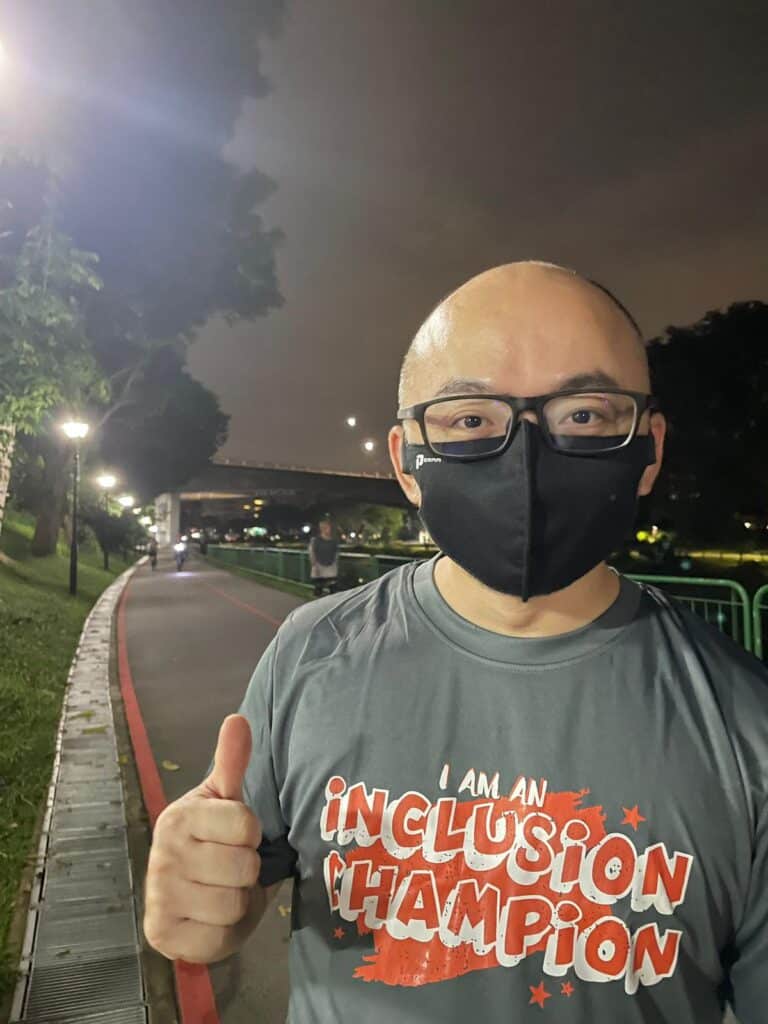 Walk participant Mr Philip Pang in the grey "I am an inclusion champion" SPD Ability Walk and Run tee giving a thumbs up