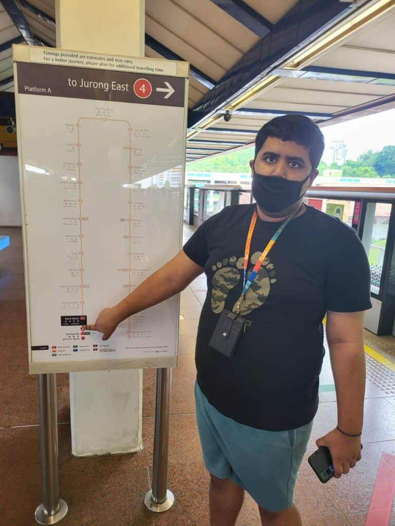 A young man pointing at a MRT signboard