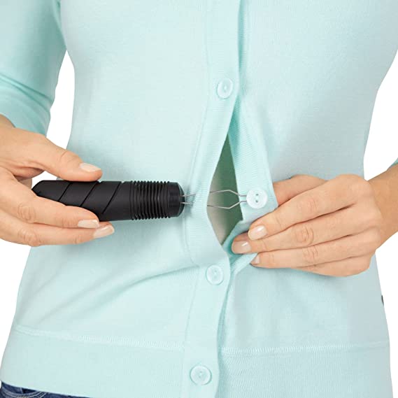 A lady using a button hook to fasten the buttons on her blouse