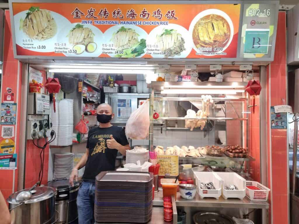 A stall holder standing in front of his hawker stall