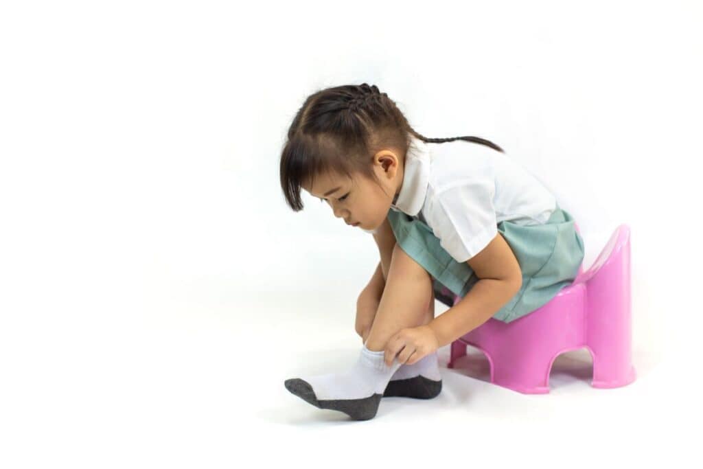 Girl on stool pulling up her sock