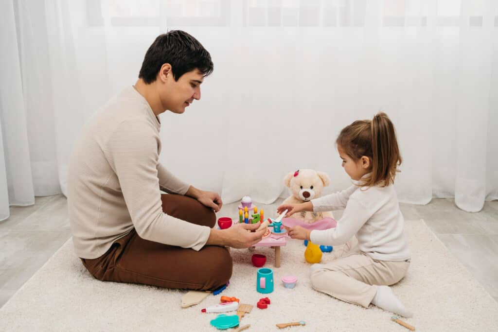 A father pretend plays tea-time with his daughter