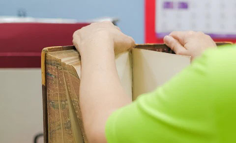 A pair of hands working on book restoration