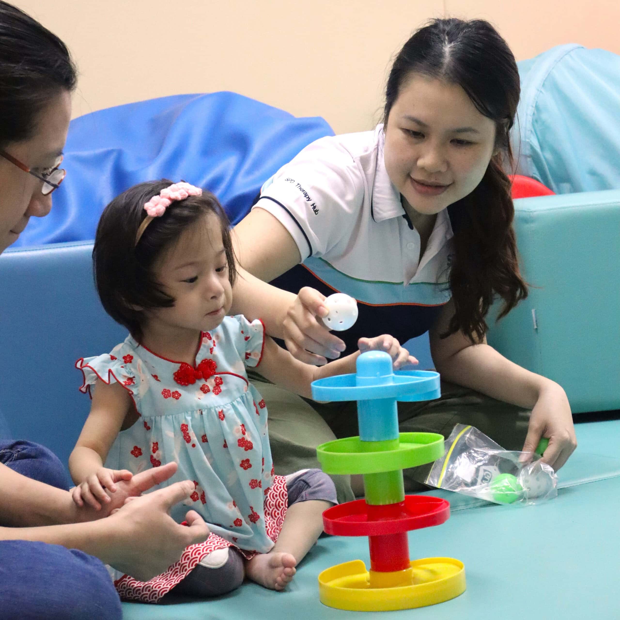 An S P D staff engaging a young girl in games.