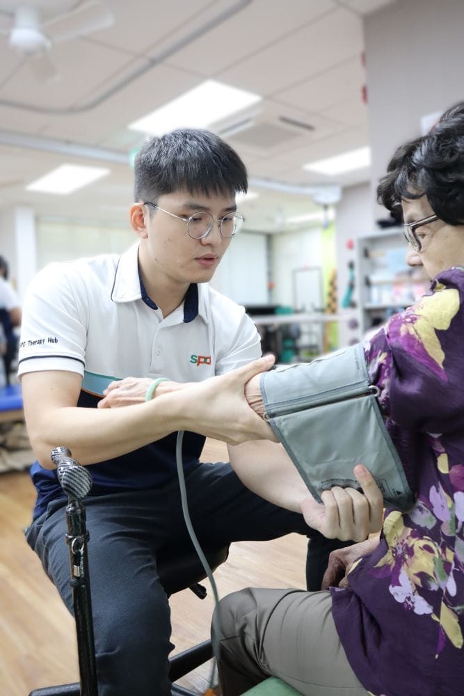 An S P D therapist takes the blood pressure of a senior