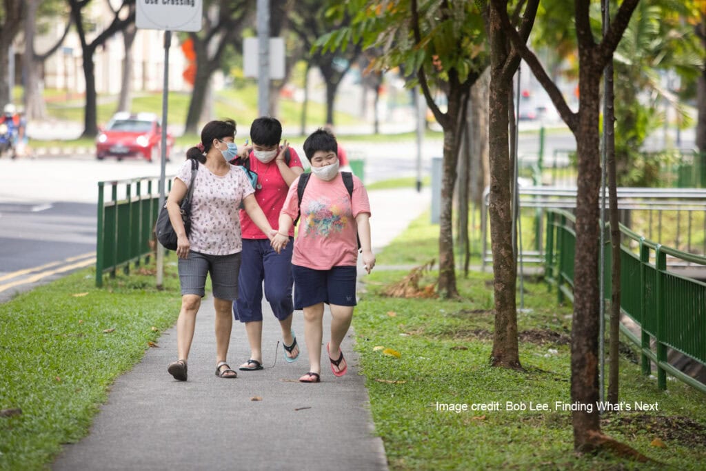 World Autism Awareness Day: A Call for Understanding and Inclusion 9 Mdm Chua Soh Ling holding Gek Hue's hand with Gek Teng walking behind them along a pavement
