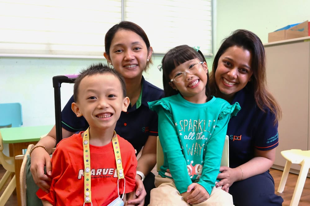 Early Intervention Programme for Infants and Children 1 2 children and 2 early intervention educators smiling happily in a classroom
