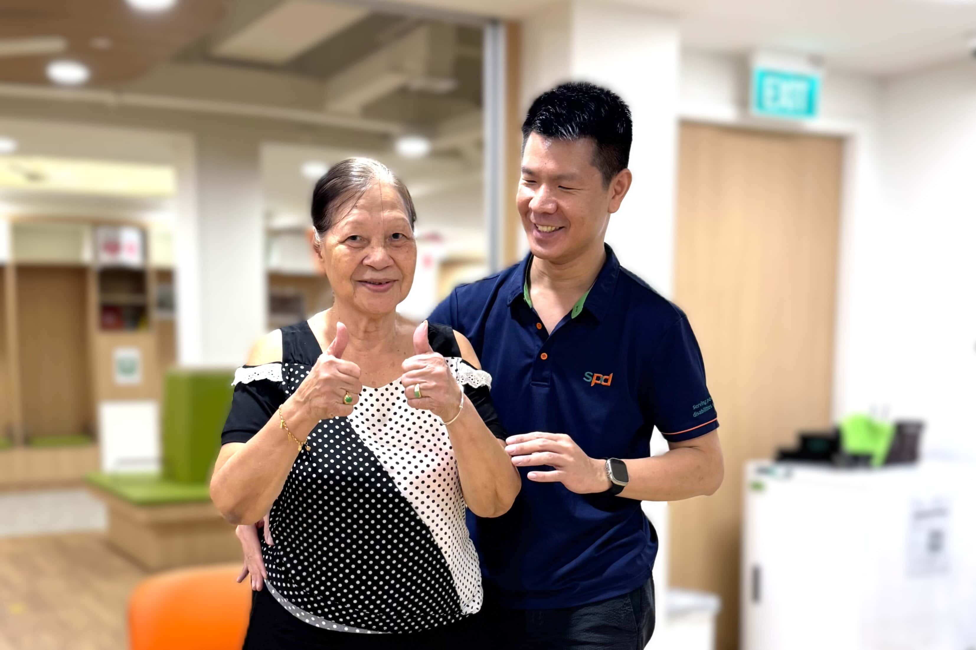 Winson with a senior both smiling and the senior giving 2 thumbs up.