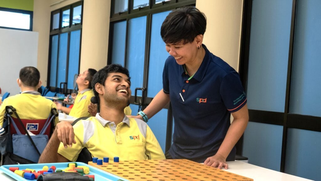 Our Story 1 Training officer with a client at the day activity centre