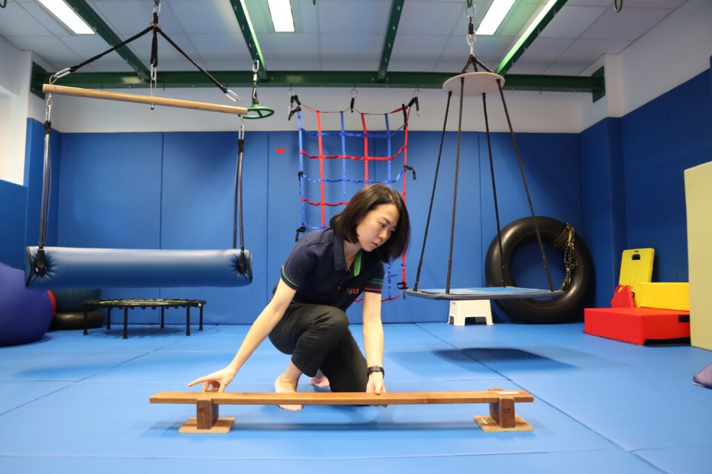 Li Wen setting up a plank inside the occupational therapy gym.