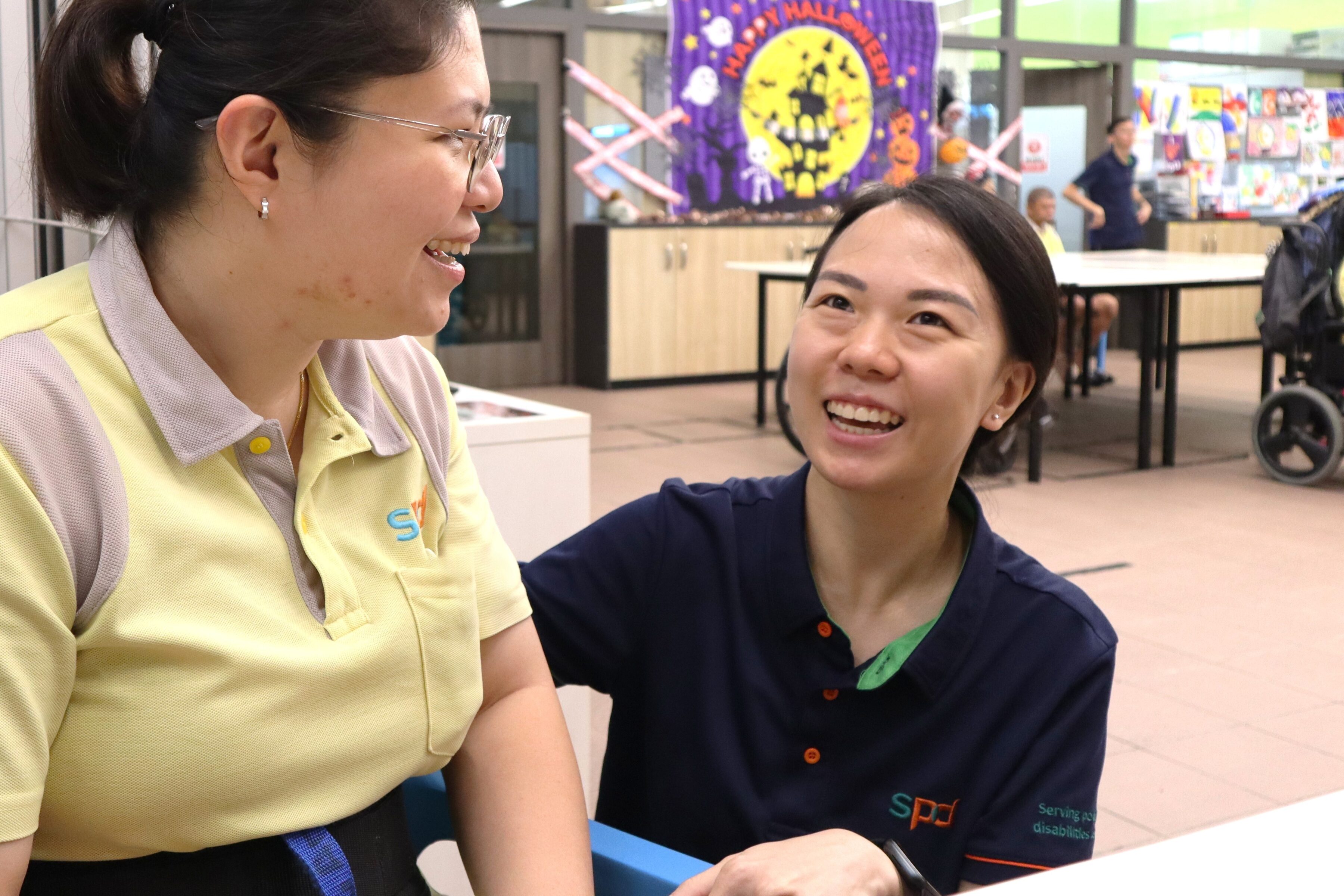 Li Wen smiling happily with a client at the E S L P Living Skills.