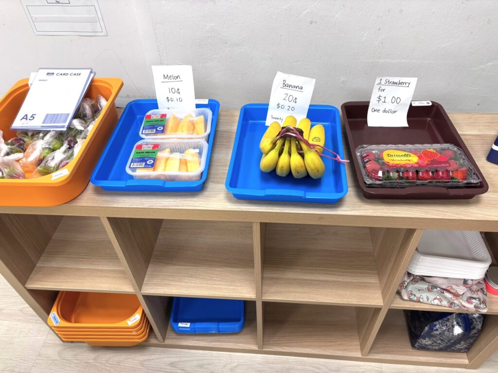 Teachers’ Day Feature: The heart behind every milestone 2 IN a classroom setting, some fruits in plastic containers and trays with pricing