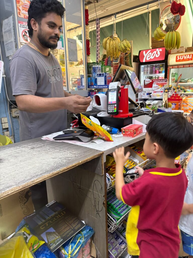 Teachers’ Day Feature: The heart behind every milestone 4 Thaddeus receiving change from a shopkeeper