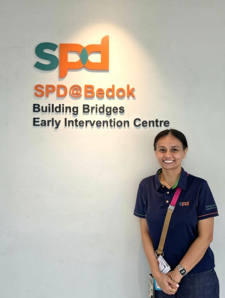 Where Purpose Found Me: Neha Parikh's journey from volunteer to teacher-aide 3 Teacher aide Neha at the main signage of S P D at Bedok